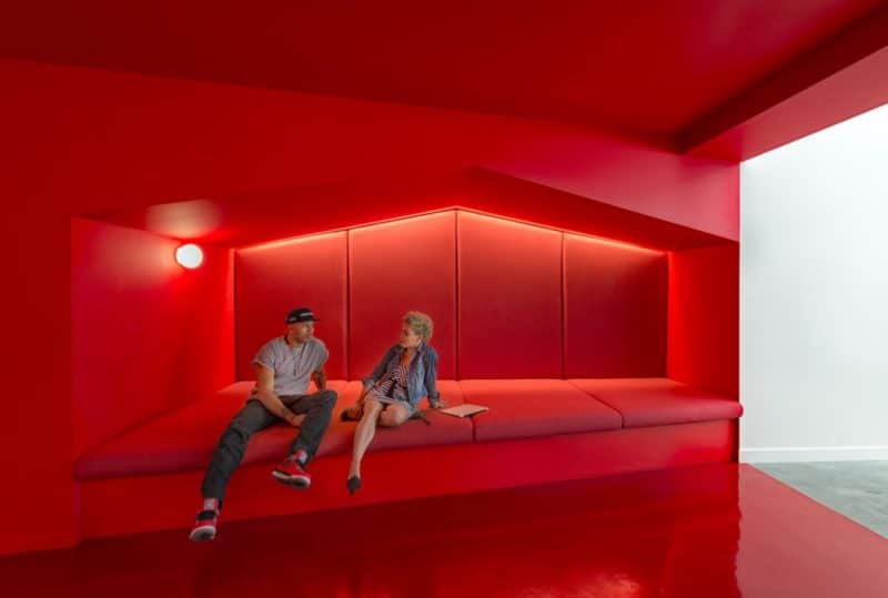 stunningly-bright-red-corridors-link-the-working-areas-together-this-hallway-even-has-a-couch-built-in