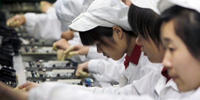 FILE-In this Wednesday, May 26, 2010, file photo, staff members work on the production line at the Foxconn complex in Shenzhen, China. Foxconn, the company that makes Apple’s iPhones suspended production at a factory in China on Monday, Sept. 24, 2012, after a brawl by as many as 2,000 employees at a dormitory injured 40 people.  The fight, the cause of which was under investigation, erupted Sunday night at a privately managed dormitory near a Foxconn Technology Group factory in the northern city of Taiyuan, the company and Chinese police said.(AP Photo/Kin Cheung, File)